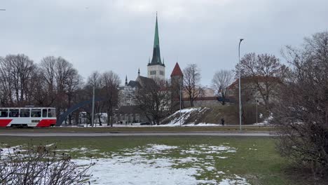 winter tranquility in tallinn: tram and cars glide through historic streets with old city backdrop