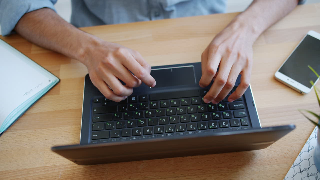 persona escribiendo en una computadora portátil en un escritorio
