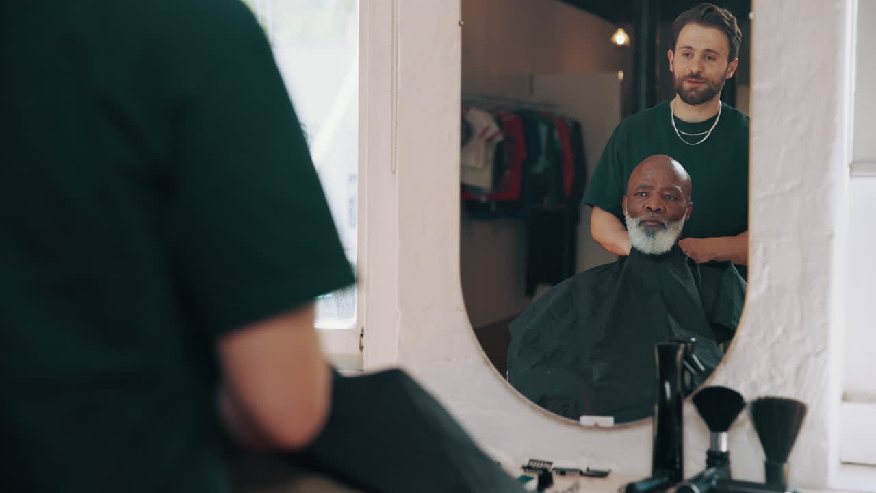 Barber Puts Cape on Client in Barbershop Mirror Reflection