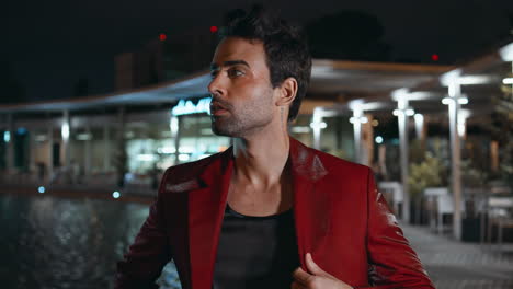brutal man relaxing night poolside club in red suit close up. rich latin macho