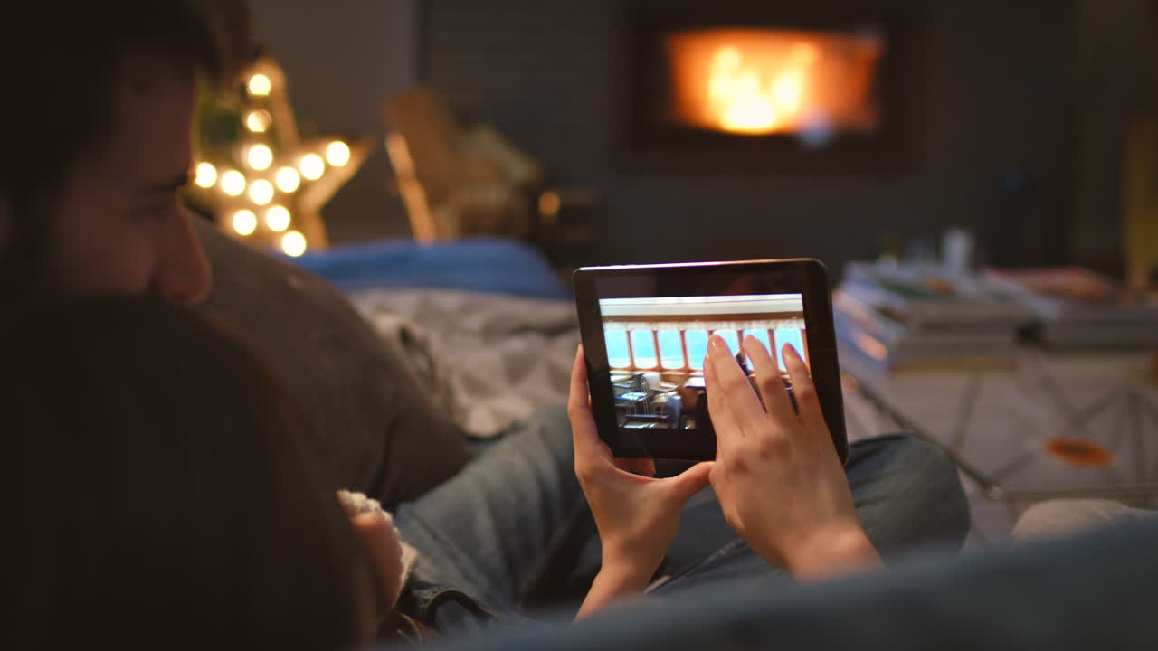 una joven pareja acurrucándose y usando un digital