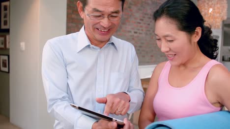 smiling couple using tablet together