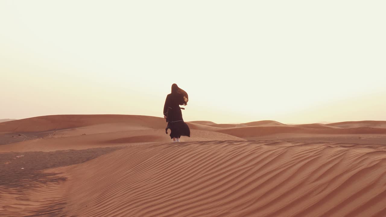Donna musulmana in piedi vicino a una moschea nel deserto. Vento forte Pace in Medio Oriente senza guerra