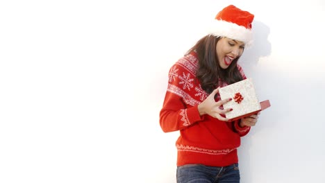 Brunette-Girl-in-Santa-Claus-Hat-Opening-Gift