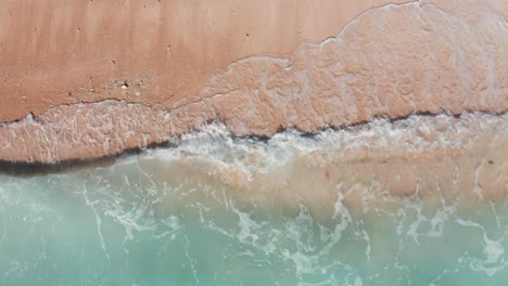 Tropical-beach-with-turquoise-ocean-water-and-foaming-waves,-aerial-view