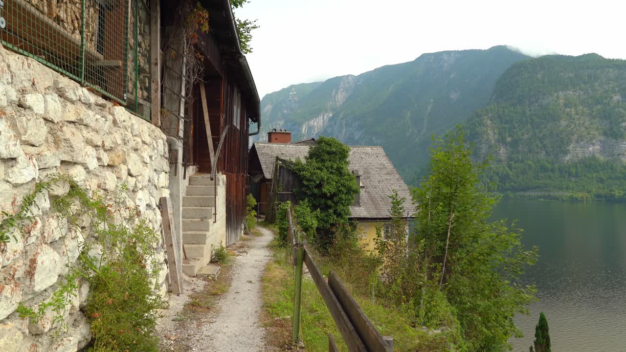 Sentiero ripido che attraversa case costruite sul pendio della montagna a Hallstatt