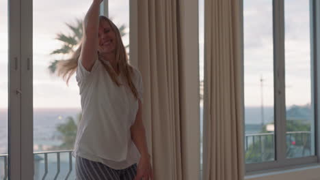 happy travel woman dancing in hotel room having fun celebrating summer vacation enjoying carefree holiday lifestyle at sunrise