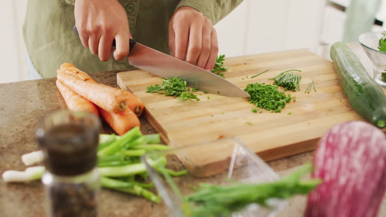 Video of hands of biracial woman cutting chives