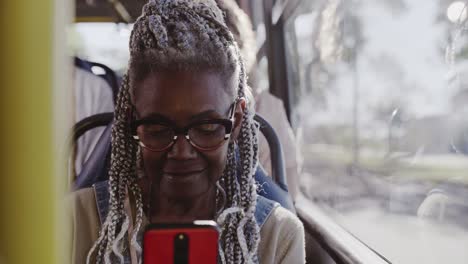 Senior African American Woman Using Smartphone on a Bus