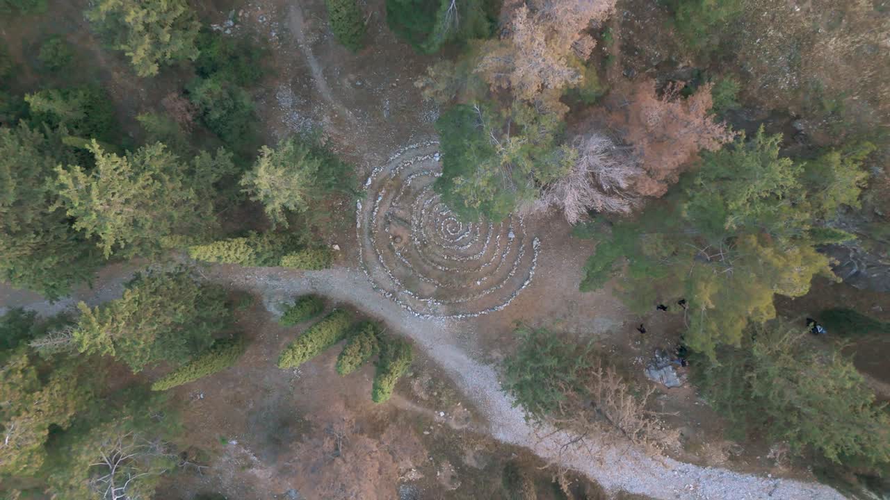Una spirale di pietre in una foresta crea un senso di mistero e calma.