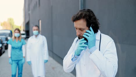 male doctor talking on mobile phone and starting to run to help patient