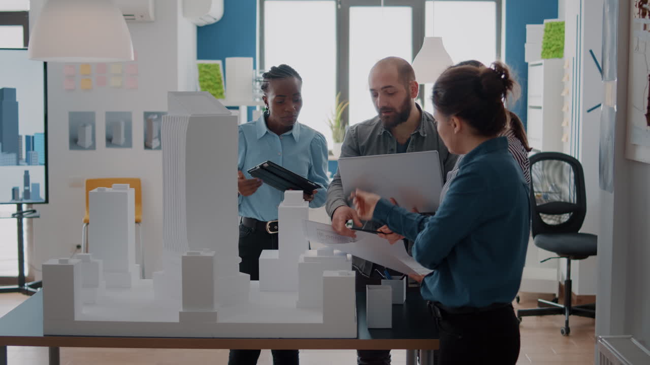 Architects collaborating on building model in office