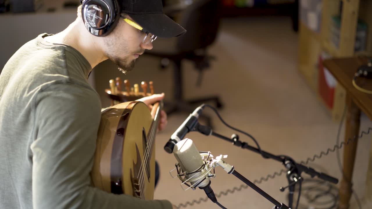 헤드폰을 착용 한 음악가 를 내려다 보고 악기 앞 에 마이크 를 들고 오드 를 연주 하고 있다