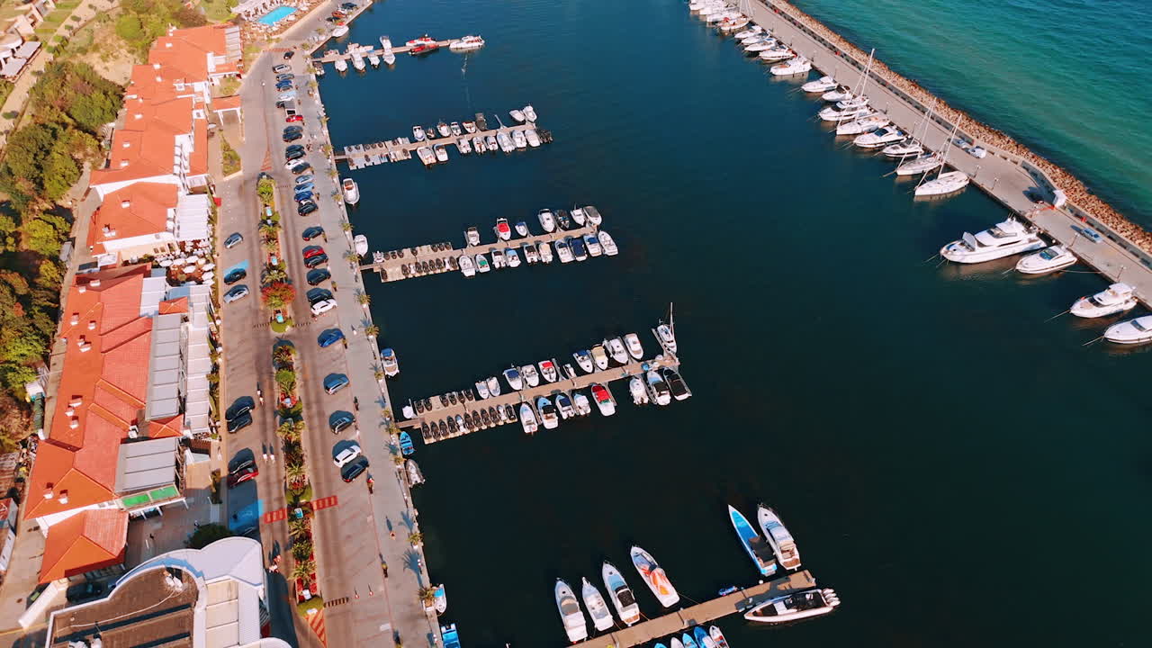Sunset marina with boats. Numerous boats are docked at a marina during sunset, with calm waters reflecting the vibrant sky colors