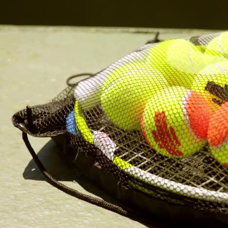 net bag of tennis balls for training on a racket