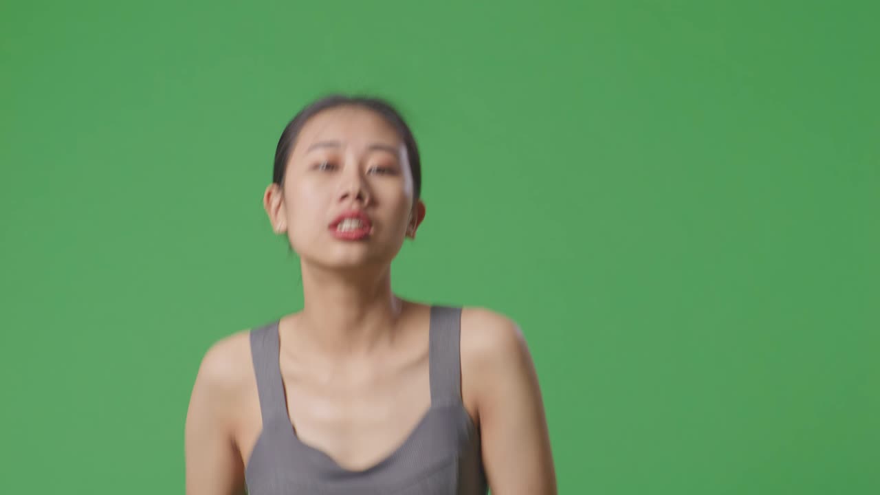 초록색 화면에 회색 크 을 입은 아시아 여성