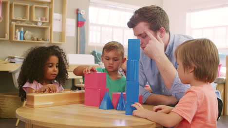 teacher and pupils using wooden shapes in montessori school