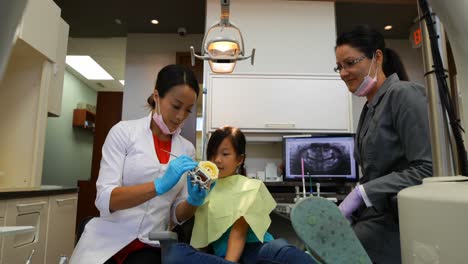 Dentista-Femenina-Explicando-Sobre-El-Modelo-De-Dientes-4k