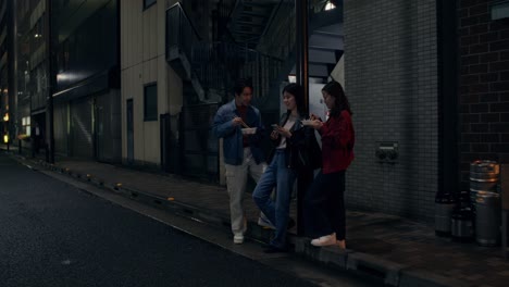 Friends Enjoying Dinner in a City Alleyway at Night