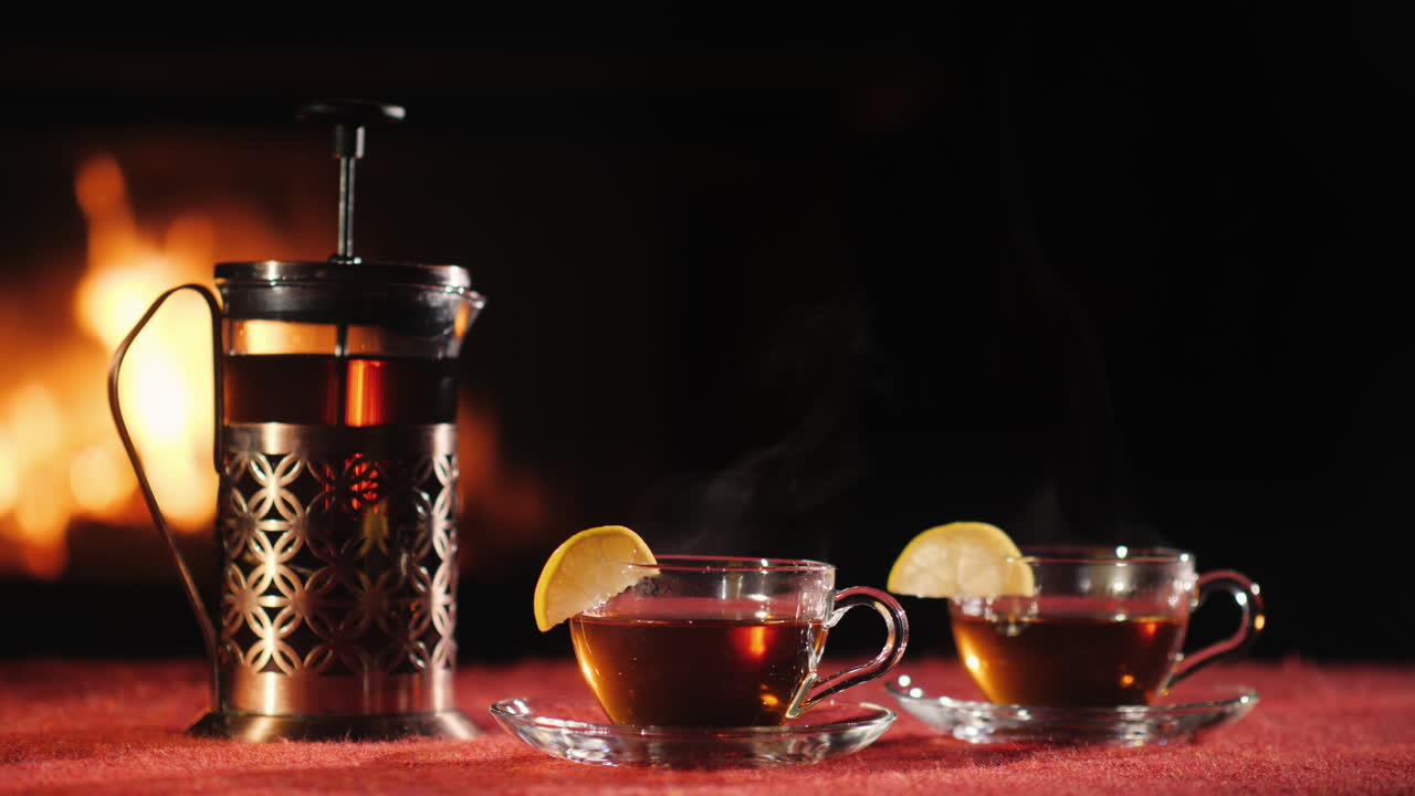 찻주전자와 찻잔 두 개는 벽난로 배경에 놓인 탁자 위에 놓여 있다.