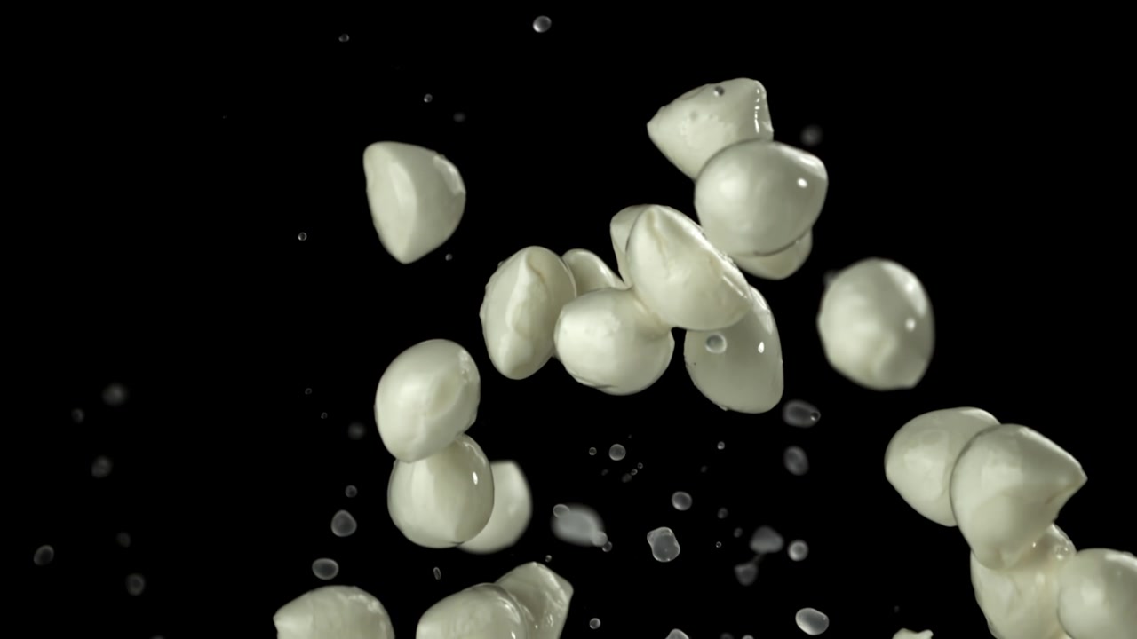 Palline di mozzarella fresca che cadono al rallentatore con schizzi