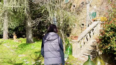 asian woman exploring the surroundings of an old rustic cottage during the day