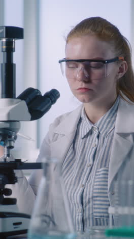 scientist using a microscope in a laboratory