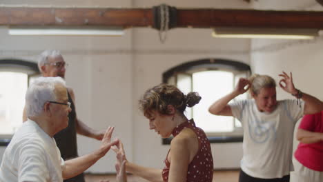 plano medio de personas mayores felices organizando discoteca en el salón de baile