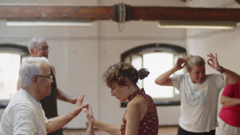 medium shot of happy senior people arranging disco in ballroom