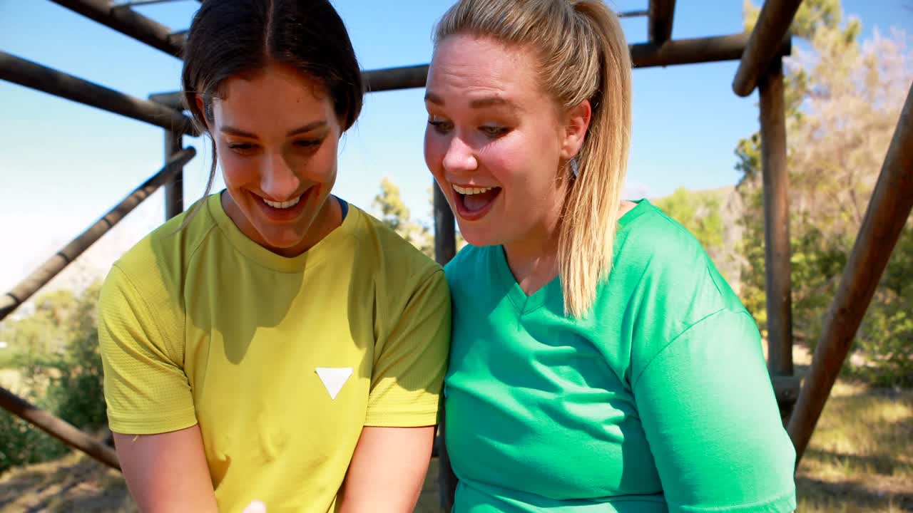 Glückliche Freunde nutzen das Handy im Bootcamp.