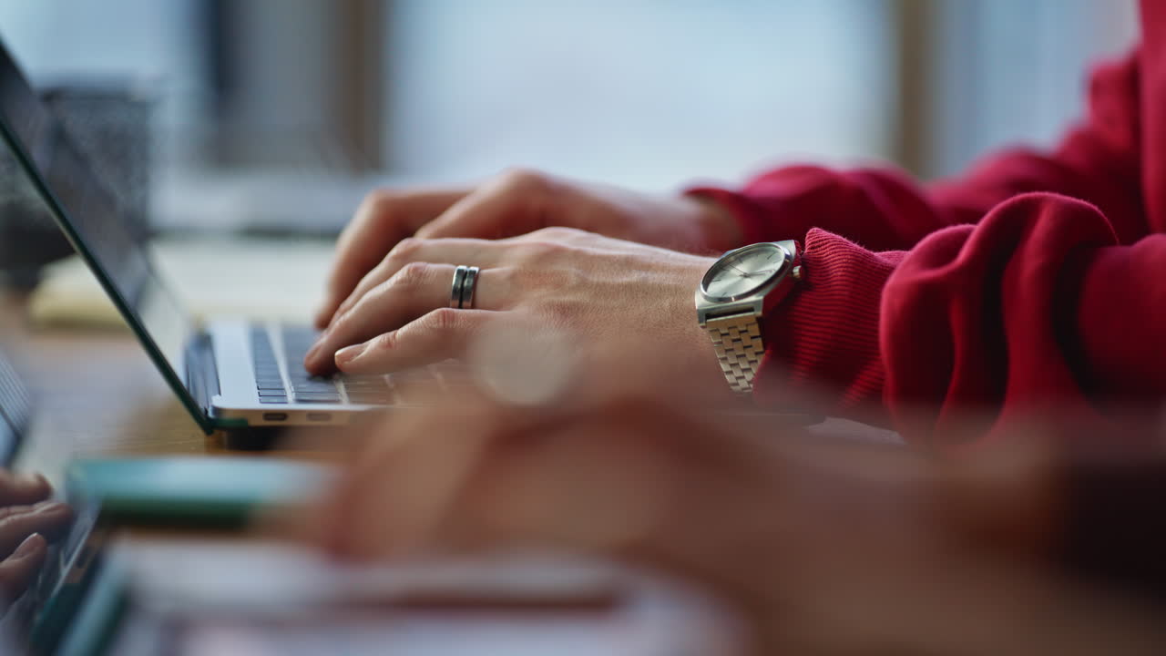 Hands typing on laptop keyboard