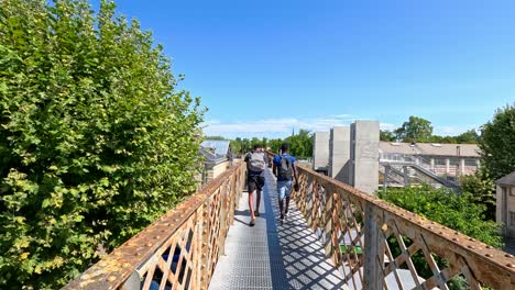 children crossing a bridge surrounded by trees