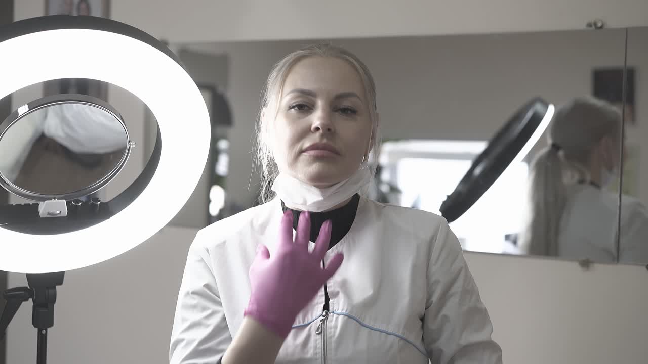 Kosmetolog fjerner maske og smiler i en skønhedssalon.