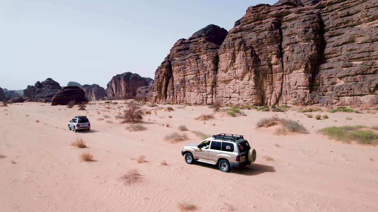 Vehicles Crossing The Sahara Desert, Tassili N'Ajjer National Park In Algeria - Drone Shot
