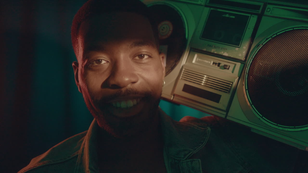 Cheerful Man with Retro Cassette Player Dancing and Smiling