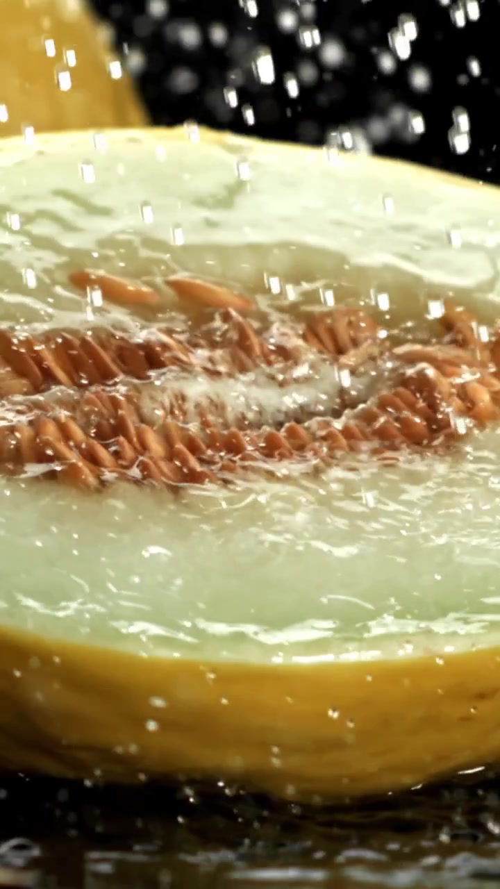 Close-up of Water Splashing on a Fresh Melon Half