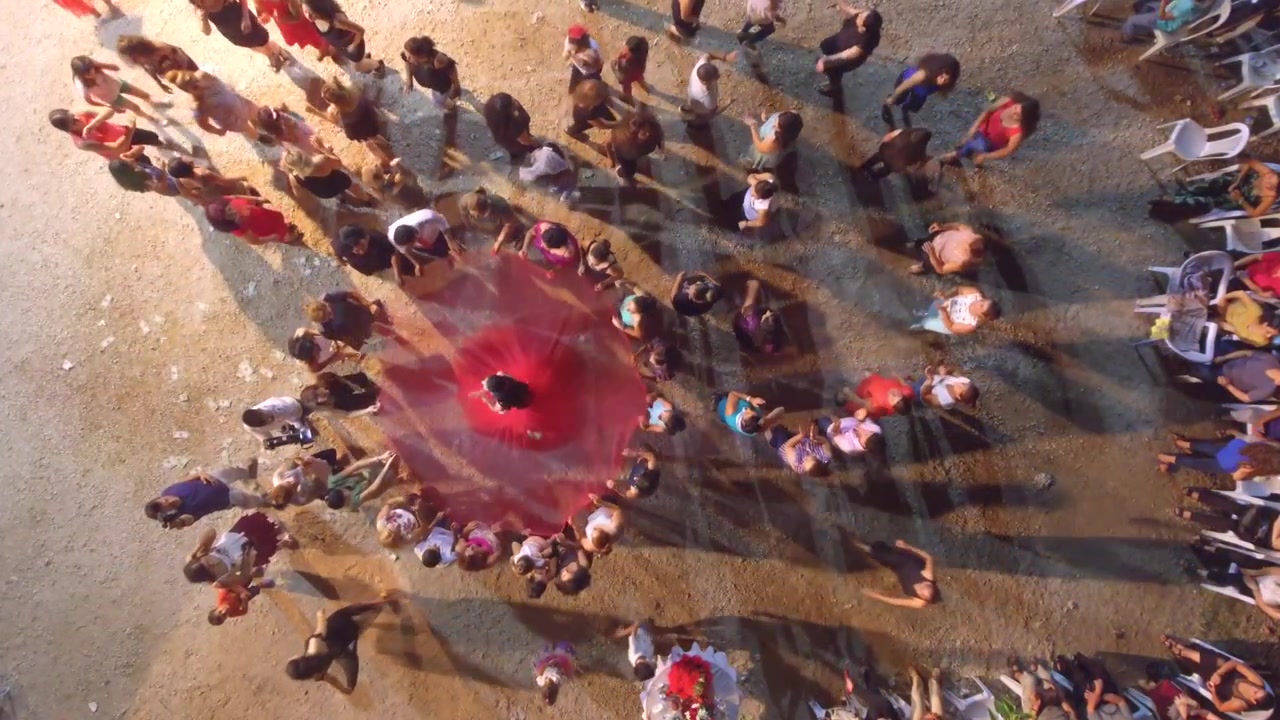 Aerial View of Woman Dancing in Red Dress Surrounded by Crowd