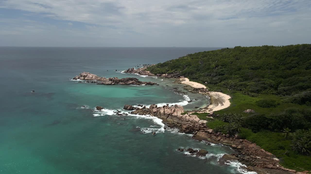 세이 ⁇ 의 라 디크 섬의 풍경은 드론으로 위에서 촬영되어 바다, 바위,  ⁇ 나무를 보여줍니다.