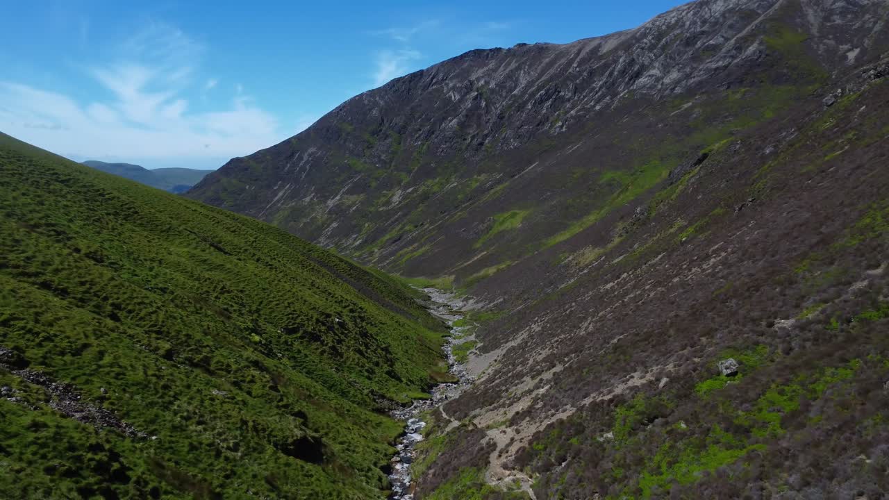 Video aereo con drone in una valle montuosa con un ruscello nel Lake District, Regno Unito.
