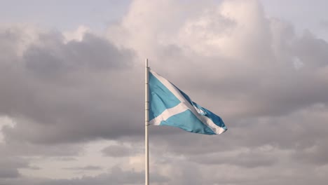 scottish flag waving in the wind on isle of skye, highlands of scotland