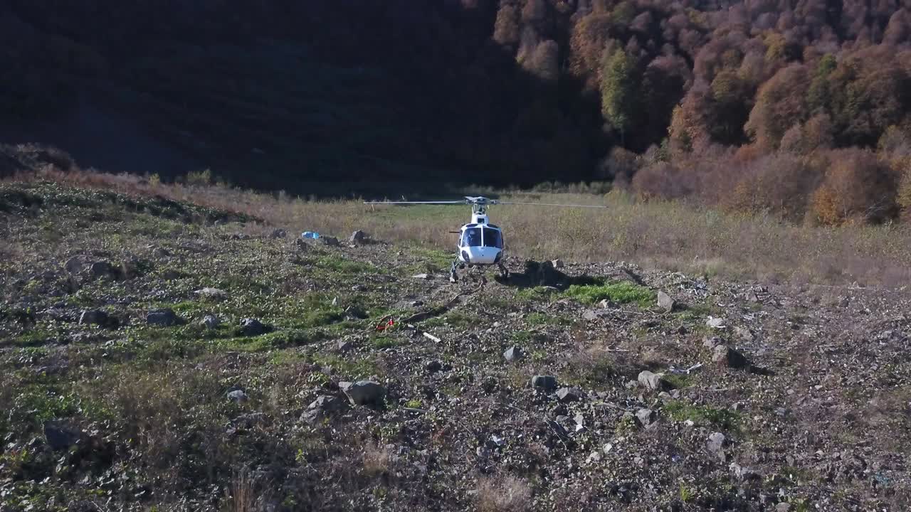하 헬리터는 산악 숲 풍경에서 이륙하기 전에 헬리패드 사이트에서 시작됩니다. 무인기에서 공중에서 볼 수 있는 하 힐리터가 하늘에서 이륙합니다. 공중 운송 및 항공 개념