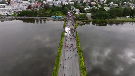 reykjavik marathon people crossing tjörnin lake in capital city, aerial