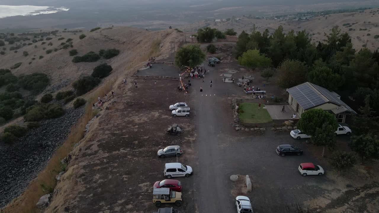vista aérea de drones sobre automóviles y personas, en un mirador en los altos del golán, atardecer en israel
