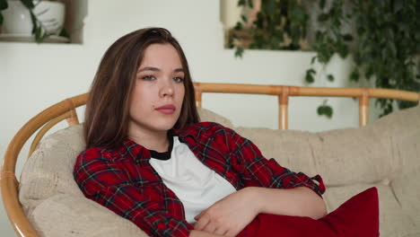 young woman in red plaid shirt relaxing on a couch