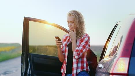 A-woman-is-talking-on-the-phone-standing-by-a-car-1