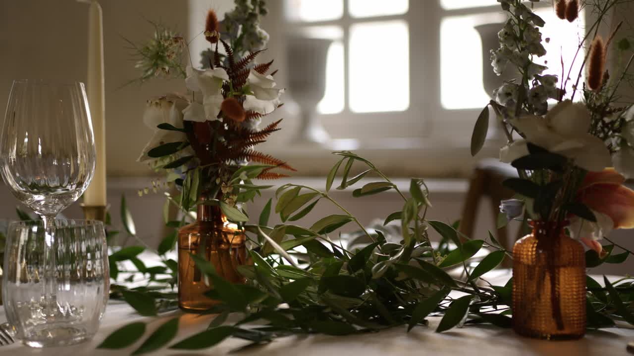 Rustic Tinted Glass Vase With Fresh Flowers And Green Foliage Decorated Over A Table. Close-up Shot