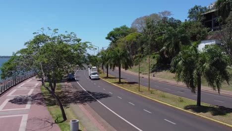 Driving-through-the-streets-of-Posadas-on-the-bank-of-the-Parana-River-connecting-Argentina-and-Paraguay,-Drone-shot