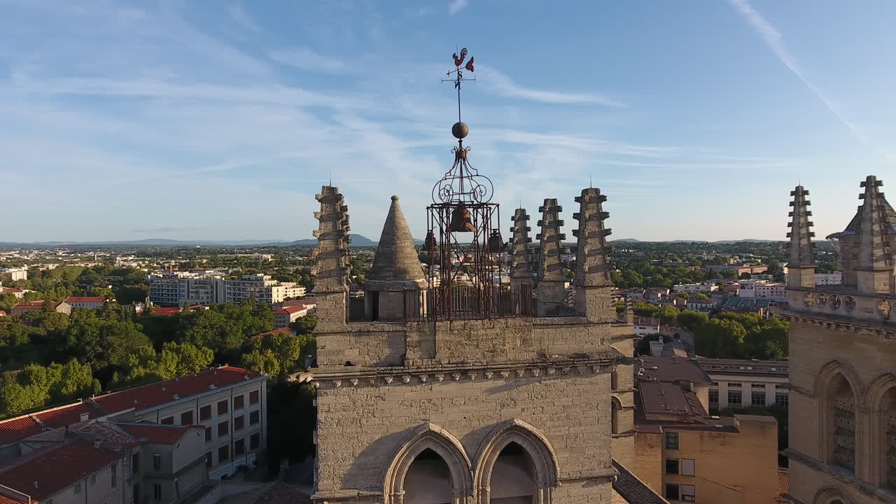Drone flying around the bell tower of Montpellier Cathedral. sunrise France