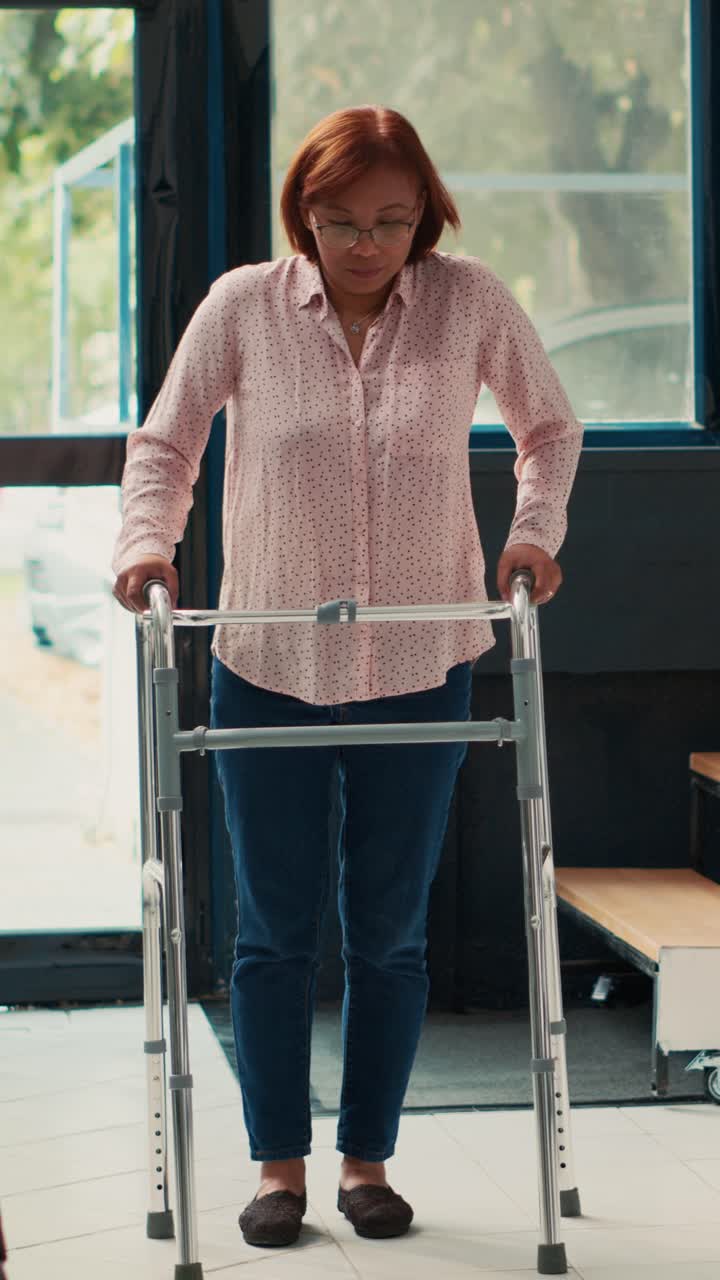 Vertical video: Elderly medic attending physiotherapy with injured patient