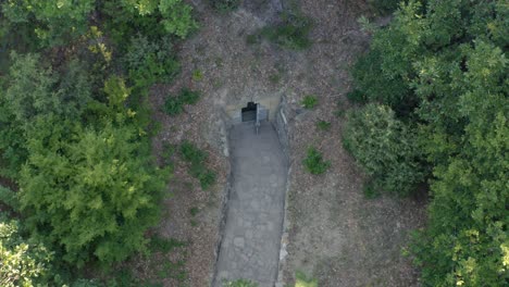 Mezek-Tomb-Entrance-With-Open-Door-Surrounded-By-Green-Forest-In-Mezek,-Bulgaria